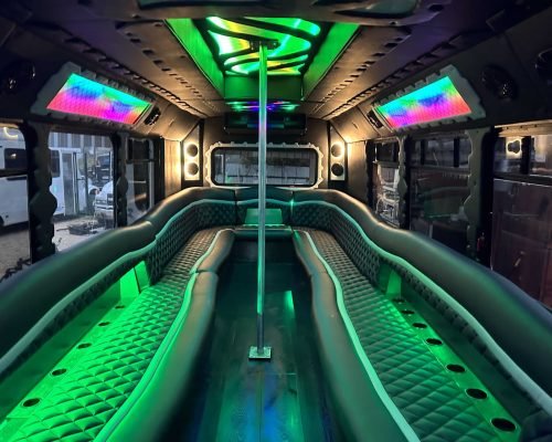 Inside a VegasLife party bus: wraparound leather seating under green and violet neon lighting